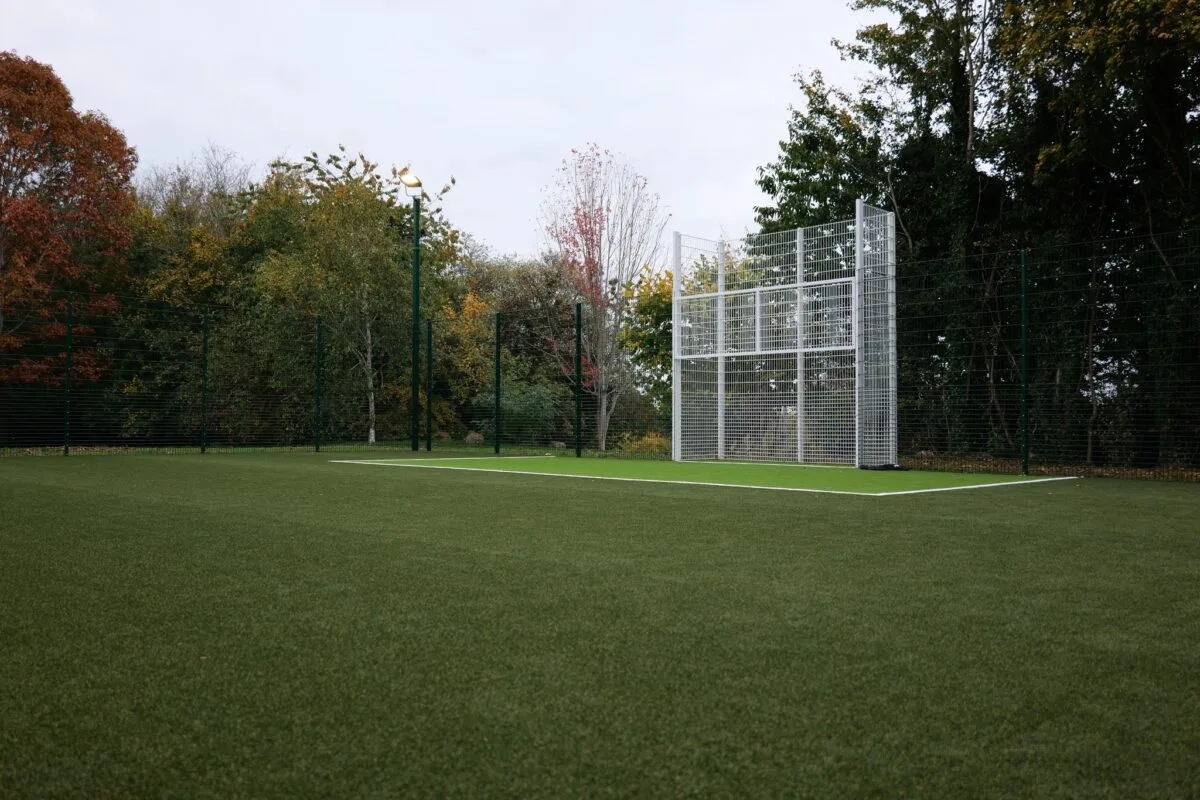 The fenced, floodlit Playzone pitch at Princess Diana Park in Banbury, with a goal frame and trees in autumn colour behind