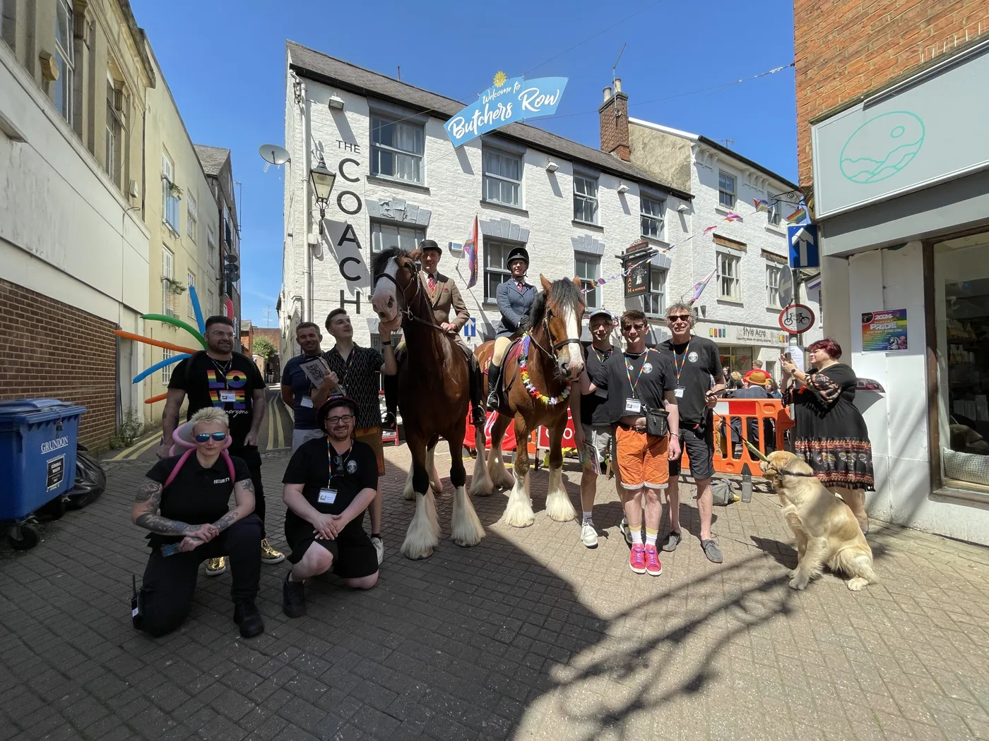 People and two of the Hook Norton Brewery horses on Butchers Row, under the street's Welcome to Butchers Row sign